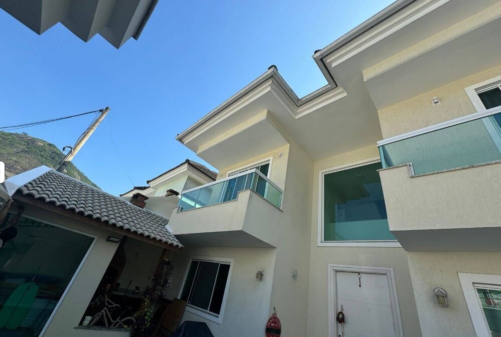 Fachada de casa com sacadas de vidro