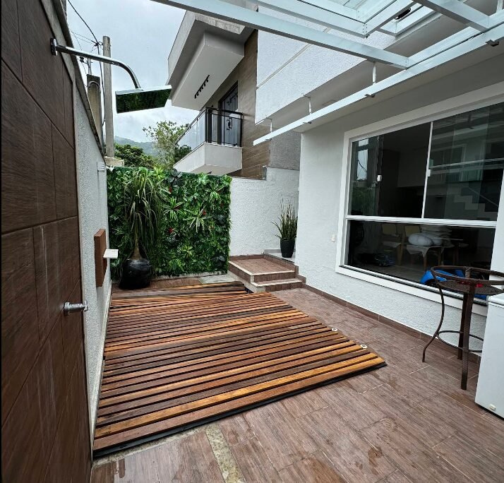 Varanda reformada com deck de madeira e jardim vertical